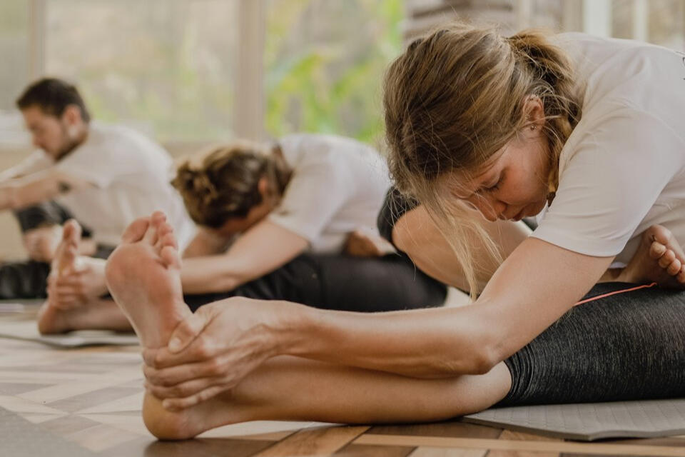 Equipo practicando yoga laboral en grupo, estiramiento guiado en oficina